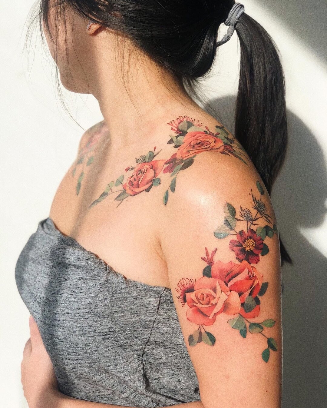 Tatuagem com flor colorida no ombro 1